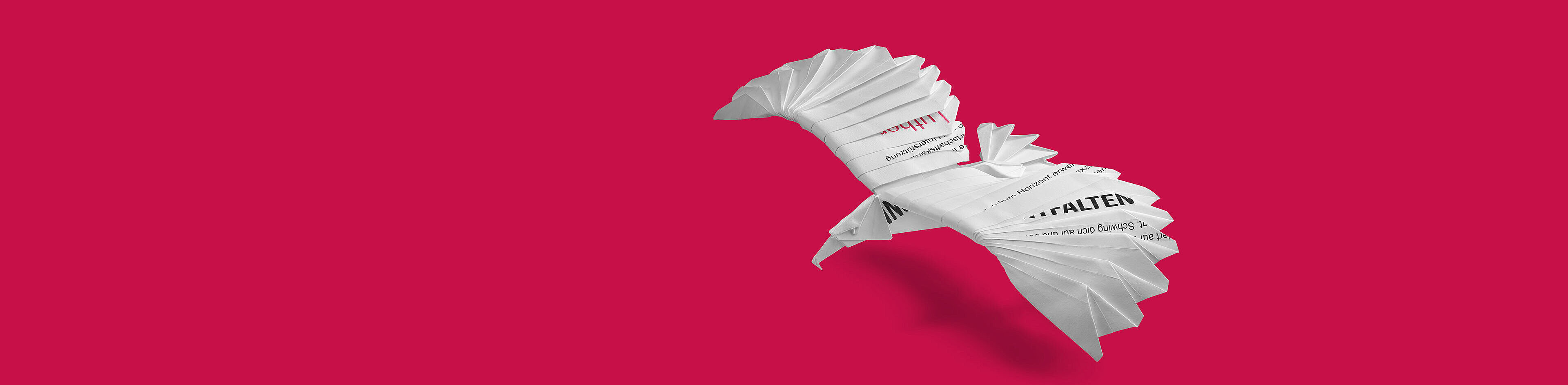 Ein origamihaft gefalteter Vogel aus Papier fliegt vor einem pinken Hintergrund. Der Vogel hat klare Konturen und ist aus mehreren Papierstreifen gestaltet, die an Seiten und Flügeln gefaltet sind, um die Form eines Vogels darzustellen.