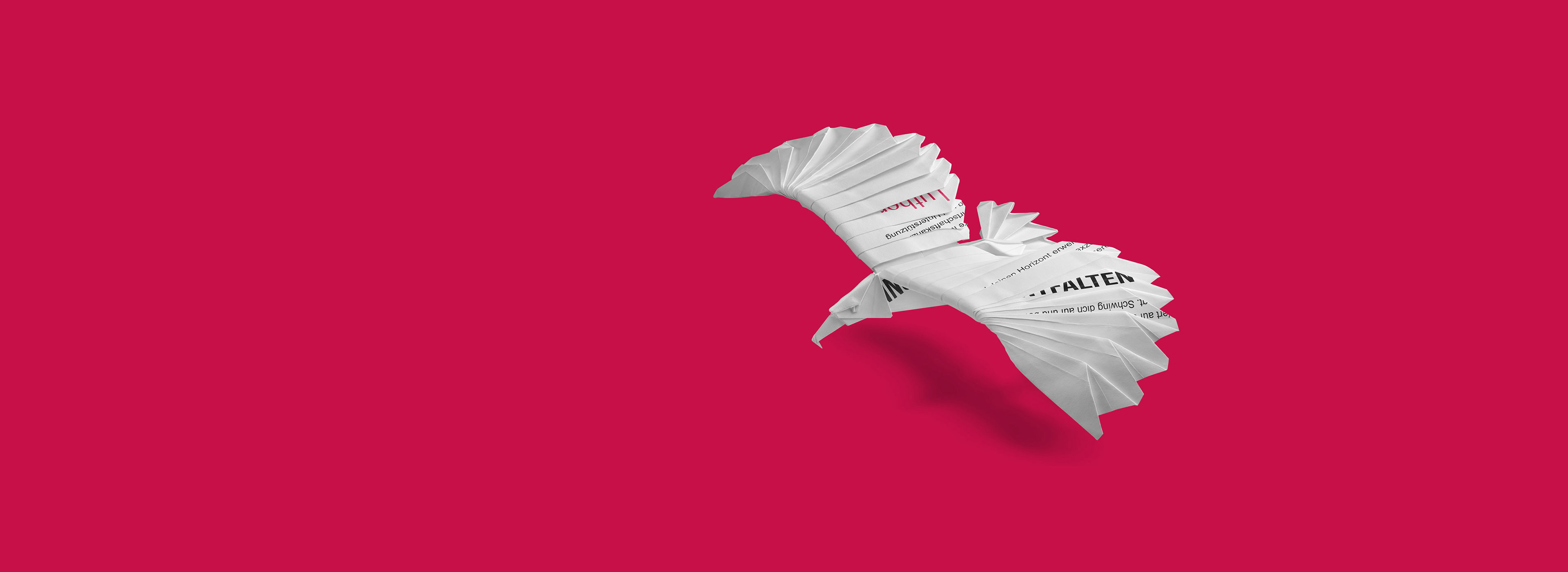 Ein origamihaft gefalteter Vogel aus Papier fliegt vor einem pinken Hintergrund. Der Vogel hat klare Konturen und ist aus mehreren Papierstreifen gestaltet, die an Seiten und Flügeln gefaltet sind, um die Form eines Vogels darzustellen.