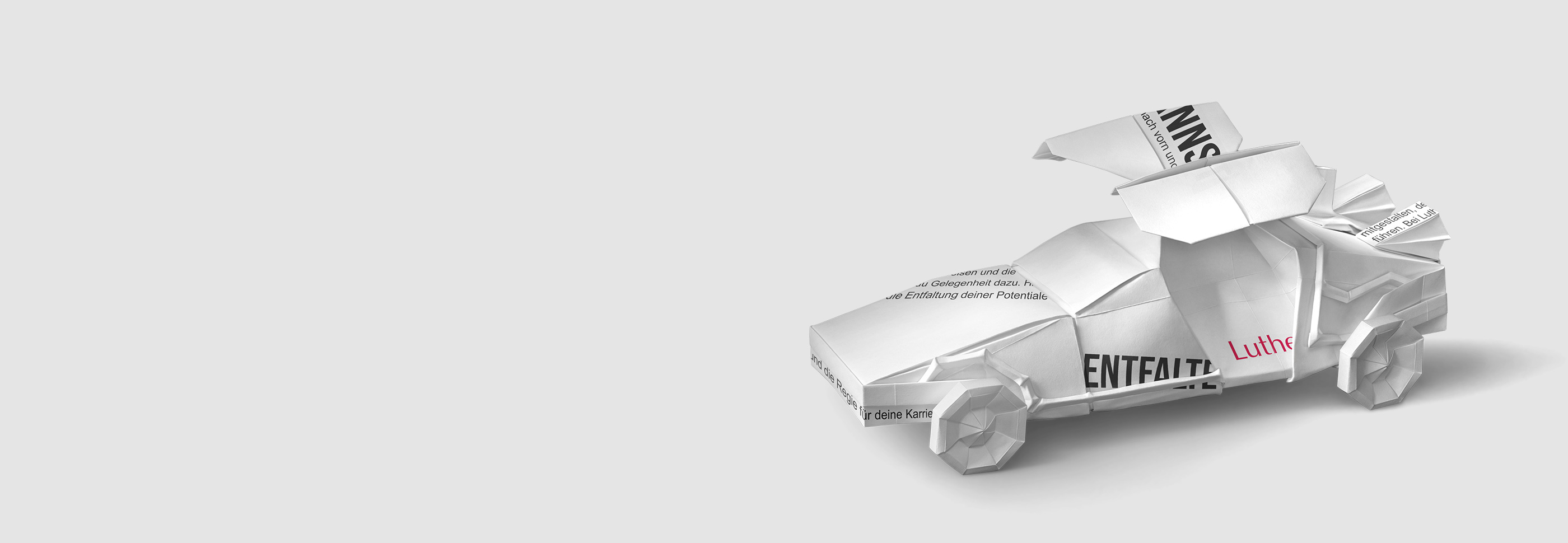 Ein Auto aus Papier, gefaltet mit verschiedenen Texten, steht im Vordergrund. Es symbolisiert Kreativität und Möglichkeiten im Zusammenhang mit Karriere und persönlicher Entfaltung. Der Schriftzug „Luther“ ist deutlich sichtbar, was auf eine Verbindung zu einem Unternehmen oder Projekt hinweist.
