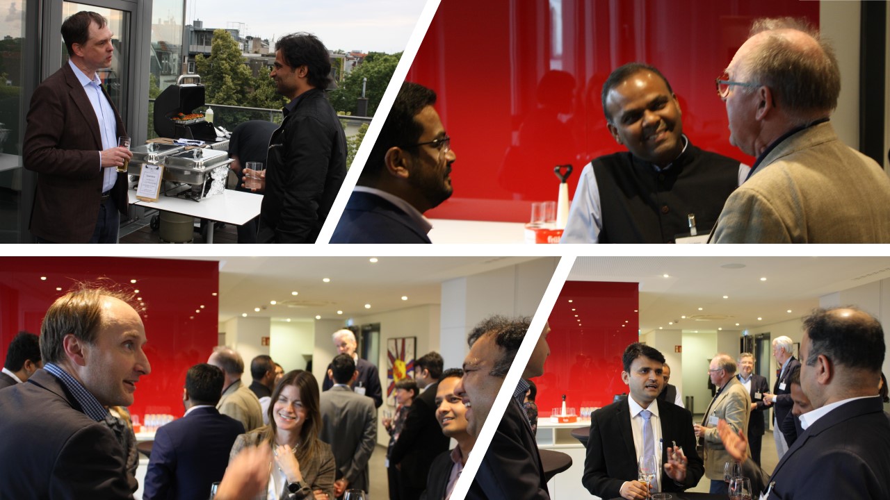 Bei einem Networking-Event stehen mehrere Personen zusammen, unterhalten sich und halten Getränke in der Hand. Im Hintergrund sind Essen und eine Bar sichtbar. Die Atmosphäre wirkt entspannt und gesellig, mit einer Mischung aus Lachen und Gesprächen unter den Teilnehmern.