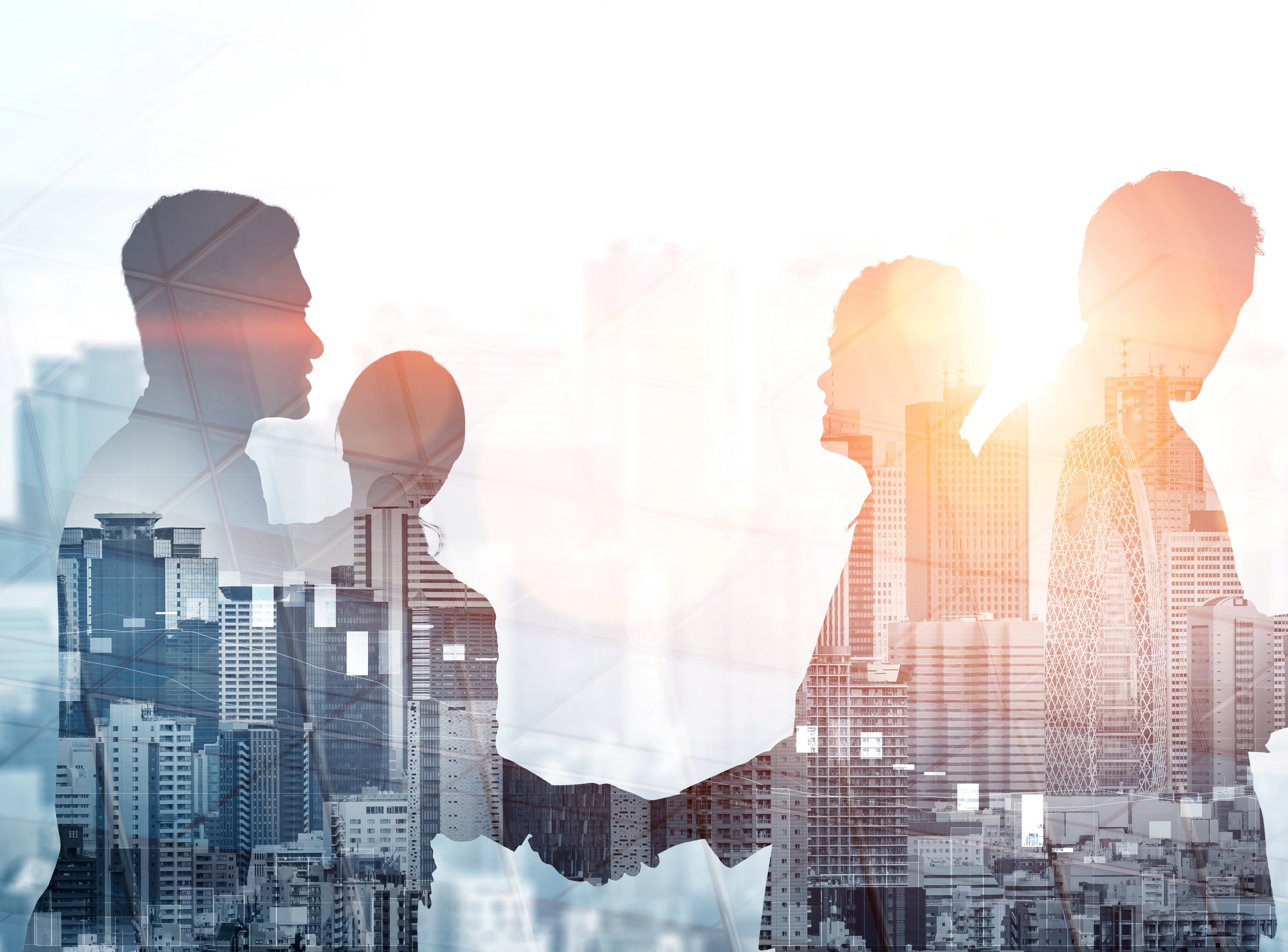Zwei Silhouetten von Personen, die sich die Hände schütteln, vor einem Hintergrund aus modernen Stadtgebäuden und Sonnenlicht. Die Szene steht symbolisch für Zusammenarbeit und Geschäftsbeziehungen in einem urbanen Umfeld.