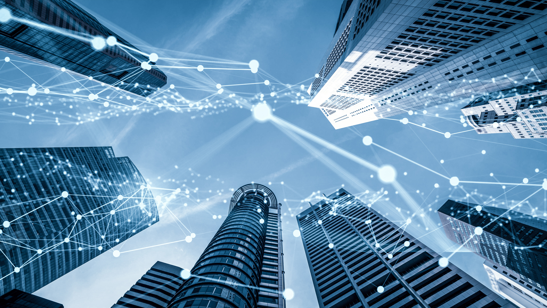Blick nach oben zwischen modernen Hochhäusern, die in einem Blau-Ton dargestellt sind. Über den Gebäuden verlaufen grafische Linien mit Punkten, die digitale Netzwerke symbolisieren, was auf technologische Vernetzung und Urbanisierung hinweist.