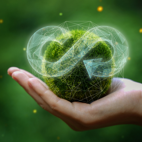 Eine Hand hält eine grüne, moosbedeckte Kugel, die symbolisch für den Planeten Erde steht. Über der Kugel schwebt das Symbol der Unendlichkeit, was Nachhaltigkeit und Kreislaufwirtschaft darstellt. Der Hintergrund ist verschwommen und grün, was eine natürliche Umgebung vermittelt.