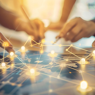 Zwei Hände zeichnen auf einer Karte, während überlappende Netzlinien und leuchtende Punkte digitale Verbindungen darstellen. Das Bild symbolisiert Zusammenarbeit und Vernetzung in einem modernen, technologischen Kontext.
