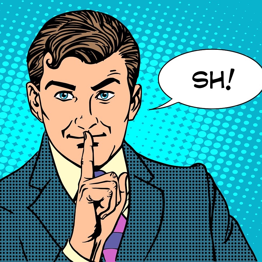 A suited man with short hair gestures for silence by placing his finger to his lips. He has a confident expression and blue eyes. A speech bubble next to him reads “SH!” against a bright blue, dotted background.