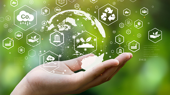 Eine Hand hält einen transparenten Globus, umgeben von Symbolen für Umwelt- und Klimaschutz, wie CO2-Reduktion und Recycling. Der Hintergrund ist grün und verschwommen, was eine natürliche Umgebung darstellt.