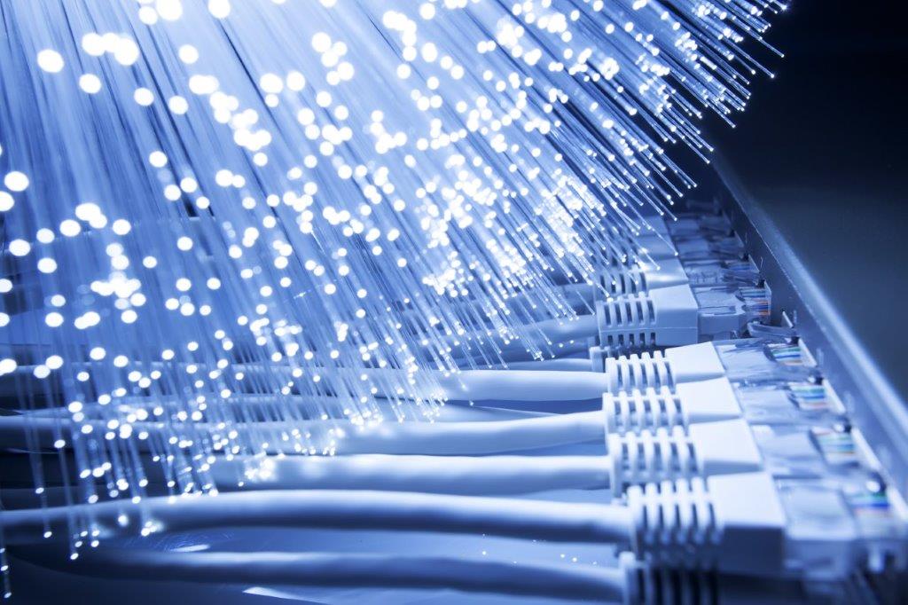 Close-up view of fiber optic cables emitting light, signifying data transmission. Below, multiple Ethernet cables are connected, illustrating a network setup. The image emphasizes the technological aspects of connectivity and communication through optical technology.
