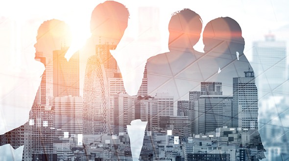 Silhouetten von Menschen vor einer Stadtlandschaft, die mit Sonnenlicht durchflutet ist. Die Darstellung vermittelt ein Gefühl von Zusammenarbeit und Vernetzung in einem urbanen Umfeld.