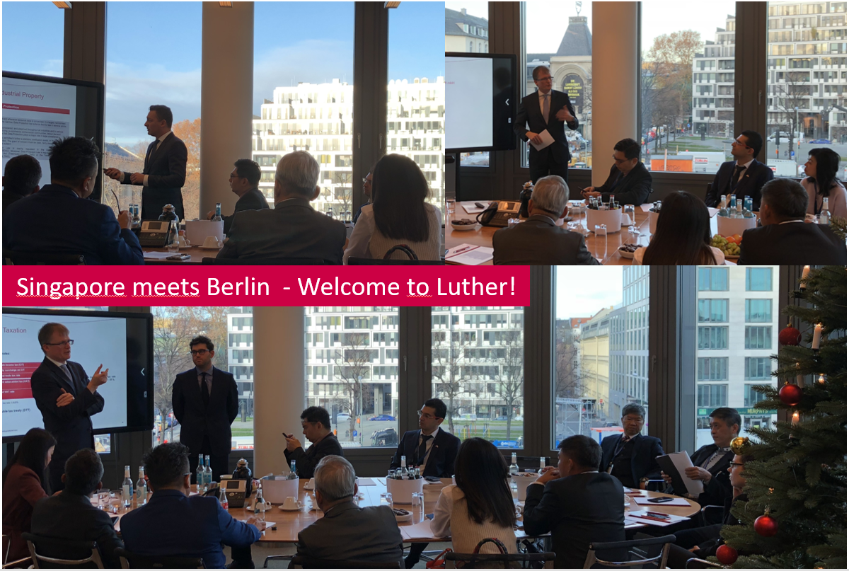 Ein Treffen von Fachleuten in einem Konferenzraum mit Blick auf Berlin. Zwei Referenten präsentieren Informationen zu Themen wie Industrie und Steuern. Die Teilnehmer, überwiegend in Anzügen, hören aufmerksam zu. Über dem Tisch stehen Wasserflaschen und es sind einige Obstschalen sichtbar.