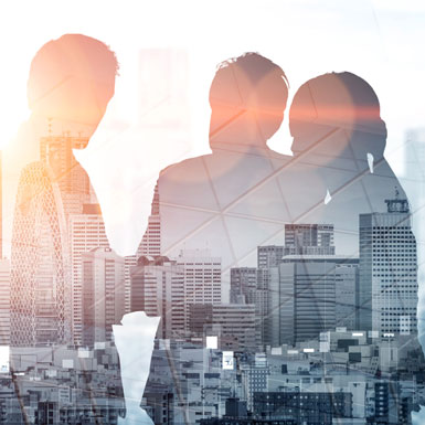 Silhouetten von drei Personen, die sich in einem urbanen Umfeld unterhalten, mit einer Stadtansicht im Hintergrund. Die Atmosphäre vermittelt einen geschäftlichen und kooperativen Eindruck, während die Skyline im Hintergrund deutlich erkennbar ist.