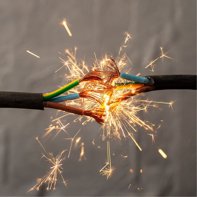 Zwei elektrische Drähte sind an ihren Enden verbunden, wodurch Funken sprühen. Die Drähte sind in verschiedenen Farben gehalten, darunter grün, blau und braun. Die Funken deuten auf einen Stromfluss oder einen Kurzschluss hin.