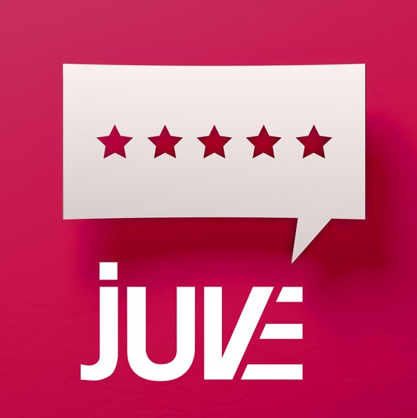 Das Bild zeigt eine weiße Sprechblase mit fünf Sternen, die die Bewertung symbolisieren. Darunter steht das Wort "JUVE" in modernen Buchstaben. Der Hintergrund ist in einem kräftigen Pink gestaltet.