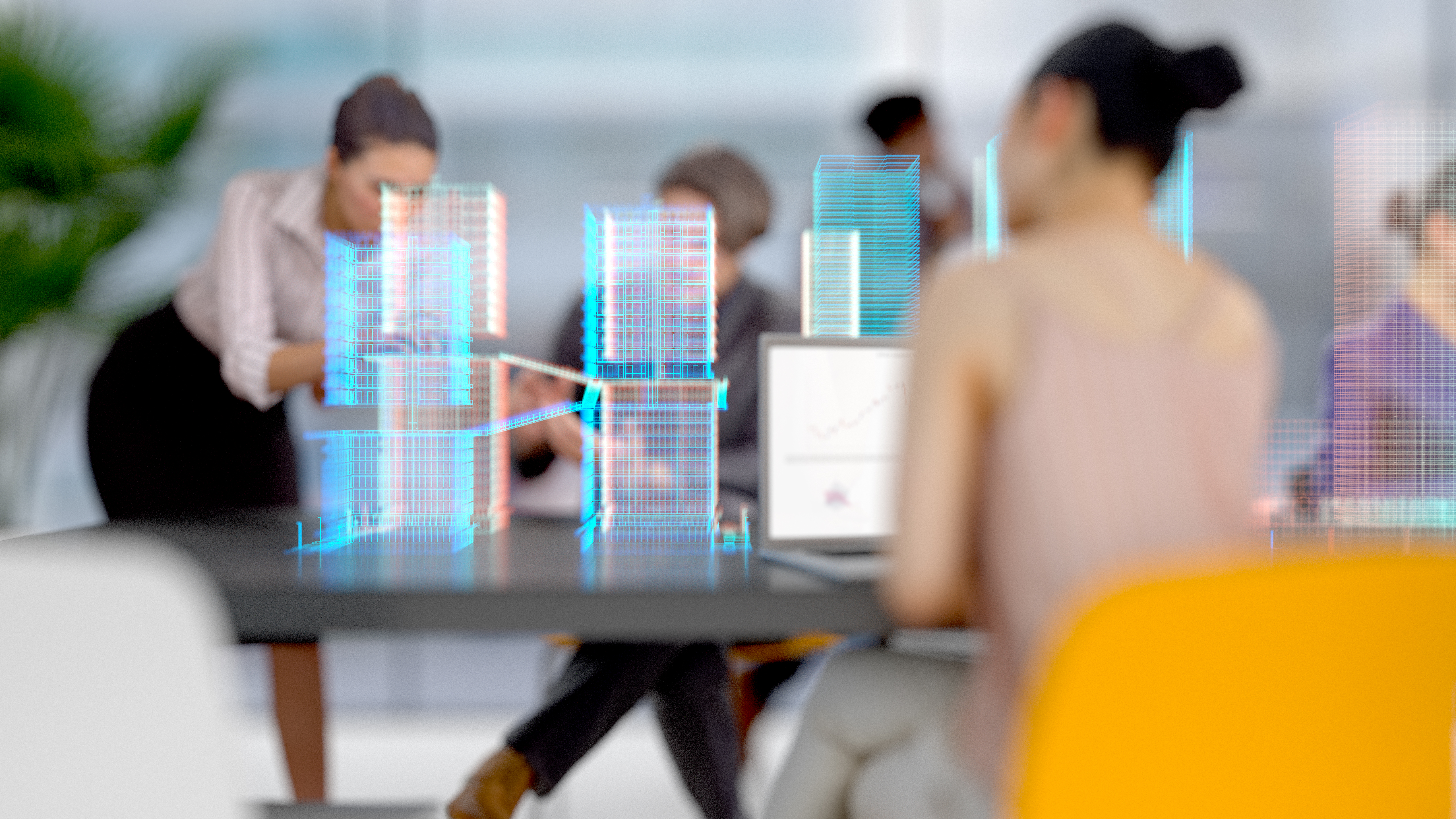 Eine Gruppe von Fachleuten im Büro arbeitet an einem Tisch. Auf dem Tisch ist ein Laptop mit einem Diagramm sichtbar. Im Vordergrund sind 3D-Modelle von Gebäuden dargestellt, die eine moderne Architekturszene zeigen. Das Ambiente vermittelt eine produktive Besprechungsatmosphäre.