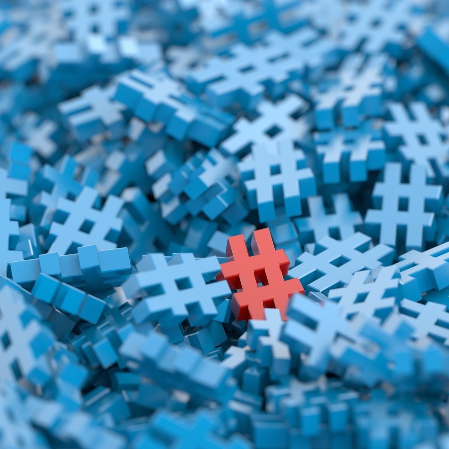 A cluster of blue hashtag symbols fills the image, with one red hashtag prominently standing out in the center. This composition emphasizes the idea of distinction or uniqueness among numerous similar elements.