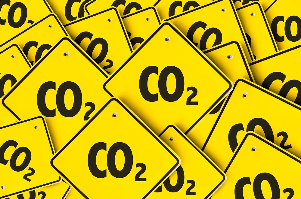 A collection of yellow warning signs featuring the text "CO2." The signs are arranged in a chaotic manner, emphasizing the theme of carbon dioxide and environmental awareness.